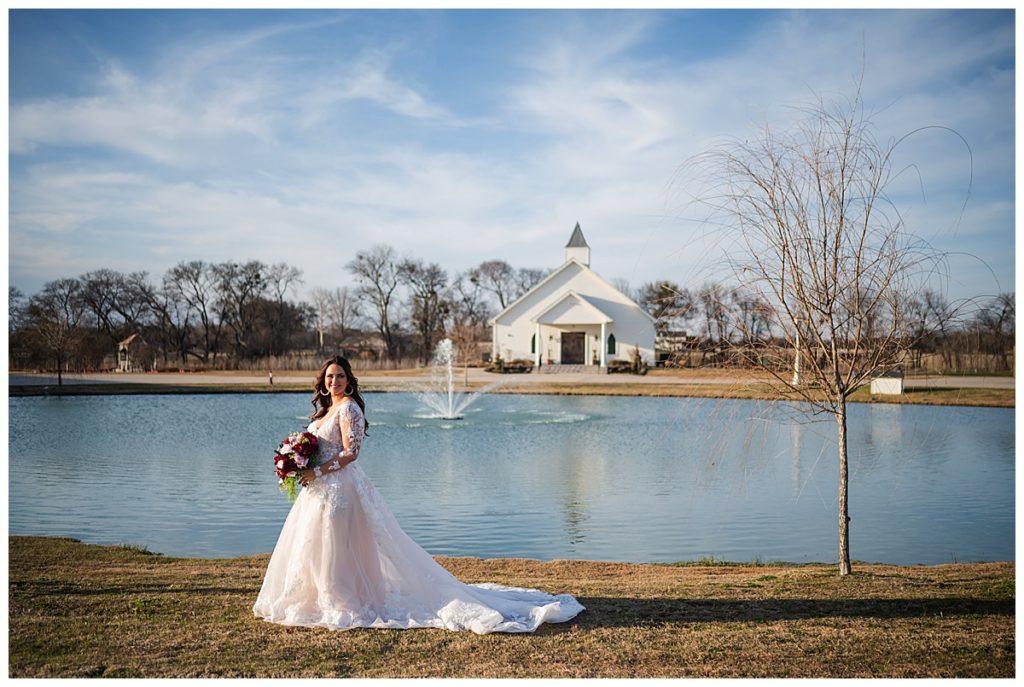 Bride by the pond with the chapel in the background at One Preston