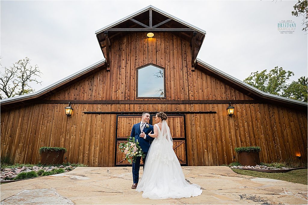Whispering Oaks Wedding Venue photo of bride and groom by barn